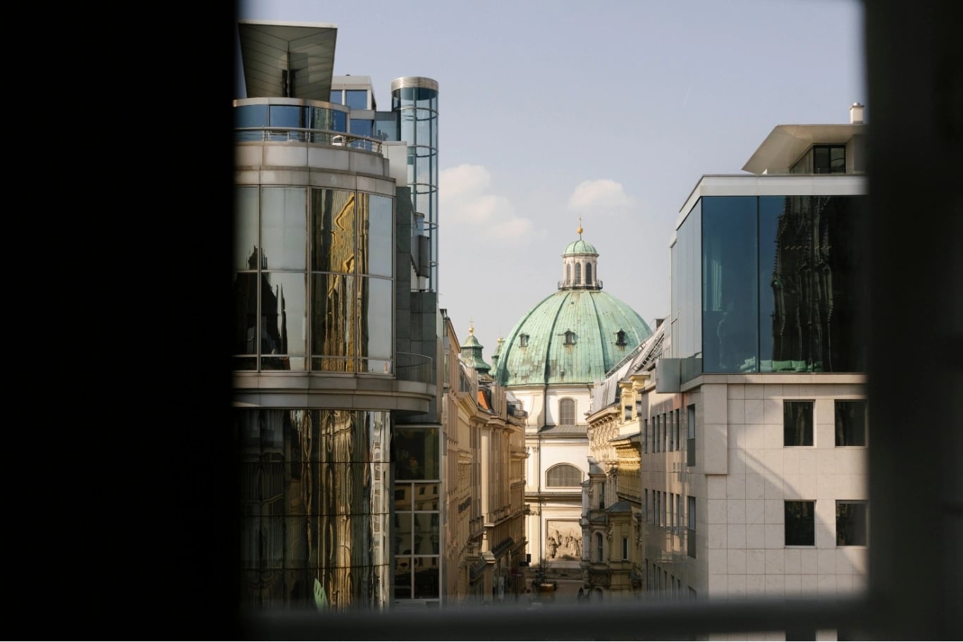 Blick zwischen Wiener Häuserfronten auf eine Kirchenkuppel